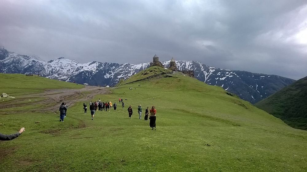 Il gruppo che sale verso la chiesa di Gergeti sotto le nuvole