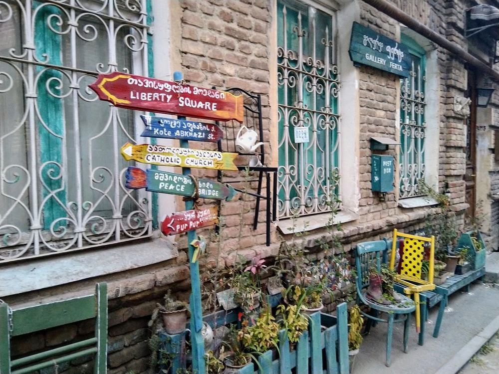 Una via di Tbilisi con i cartelli e le sedie colorate