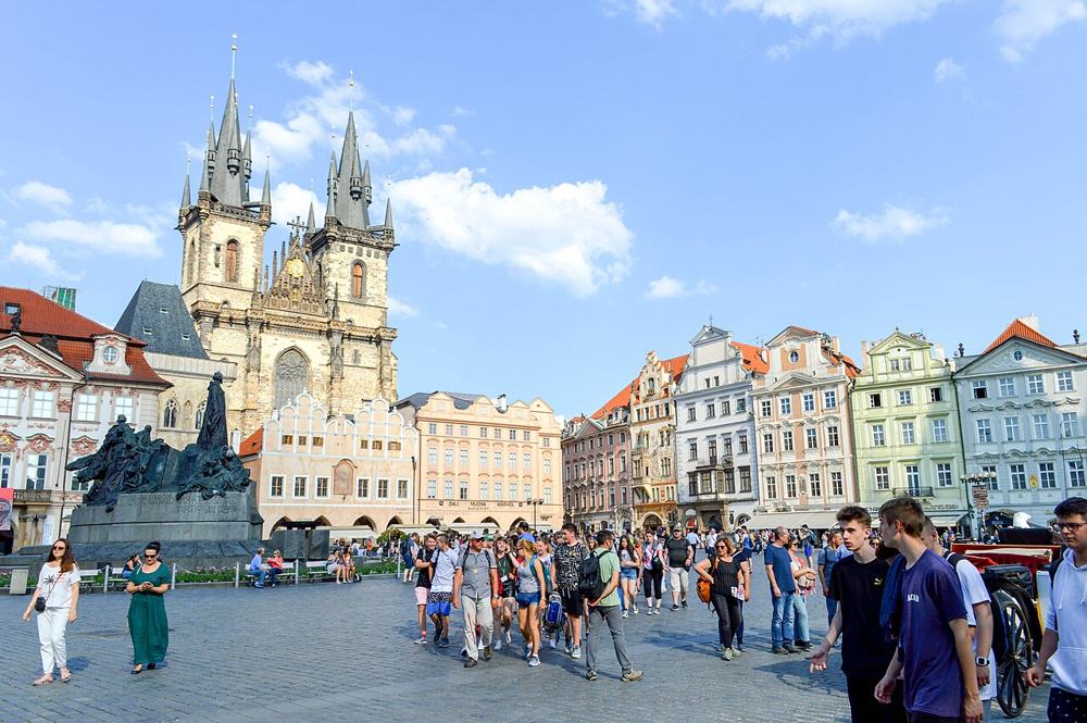 La piazza della Città Vecchia piena di gente, con la chiesa di Týn in fondo